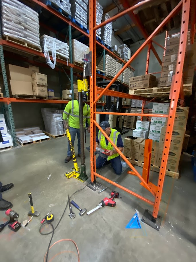 two people repairing pallet rack in a warehouse in the Bay Area